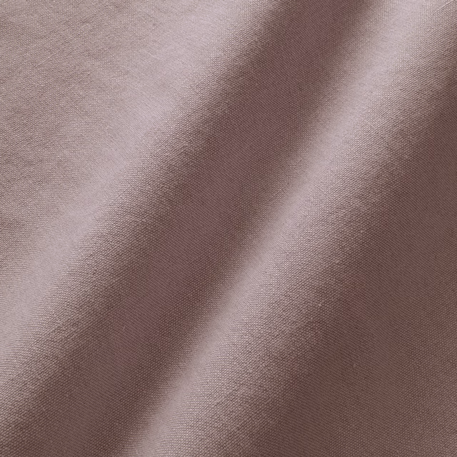 Close-up of muted mauve-lilac linen with a fine plain weave and soft folds