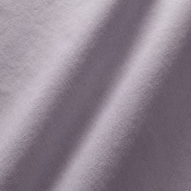 Close-up of muted grey-lilac linen with a fine plain weave and soft folds