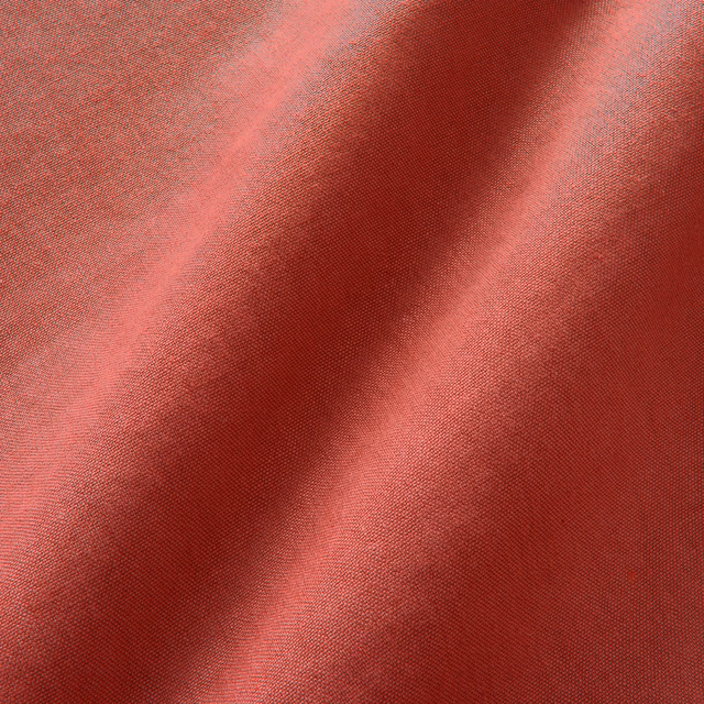 Close view of Elba Lipstick’s fine plain linen weave in layered coral-red folds
