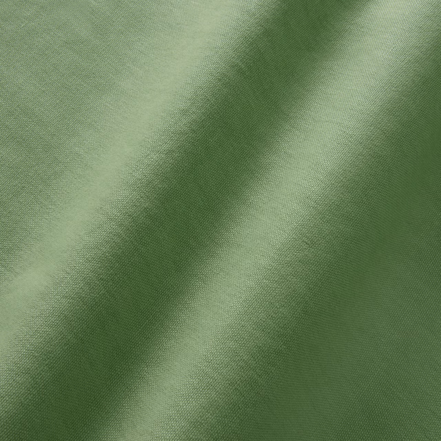 Close-up of muted mantis green linen with a fine softly textured plain weave
