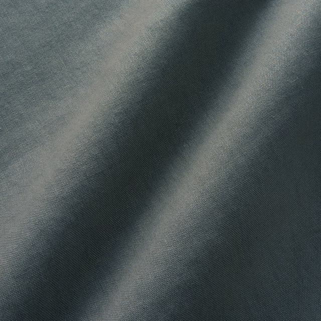 Close-up of cool pewter-grey linen with fine plain weave and smoky tonal folds