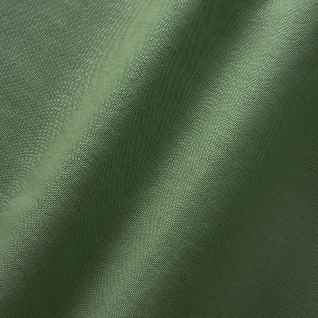 Close-up of Elba Pine linen in a deep, softly mottled pine green weave