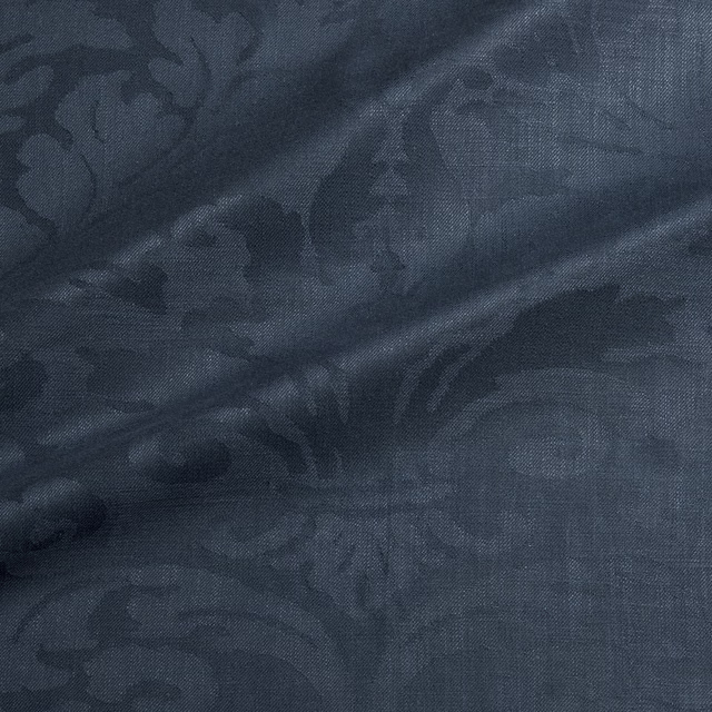 Deep blue-grey damask fabric with large tonal floral scrolls and woven texture