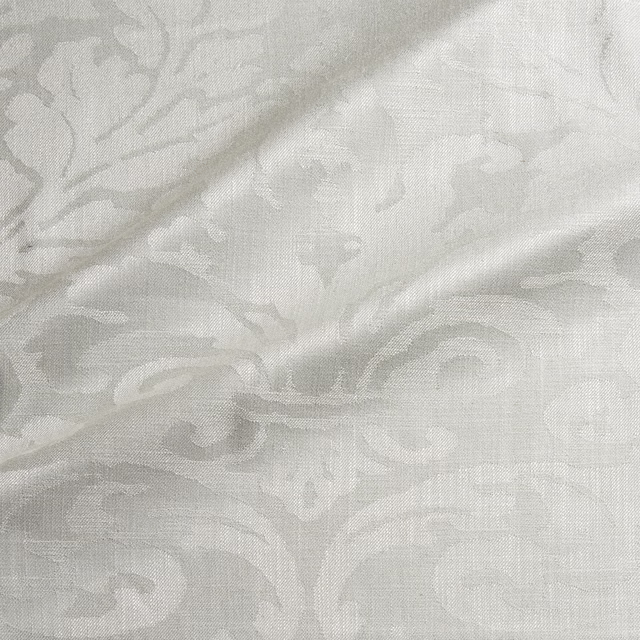Pale bone damask with ivory-grey scrolls and a softly grained woven surface