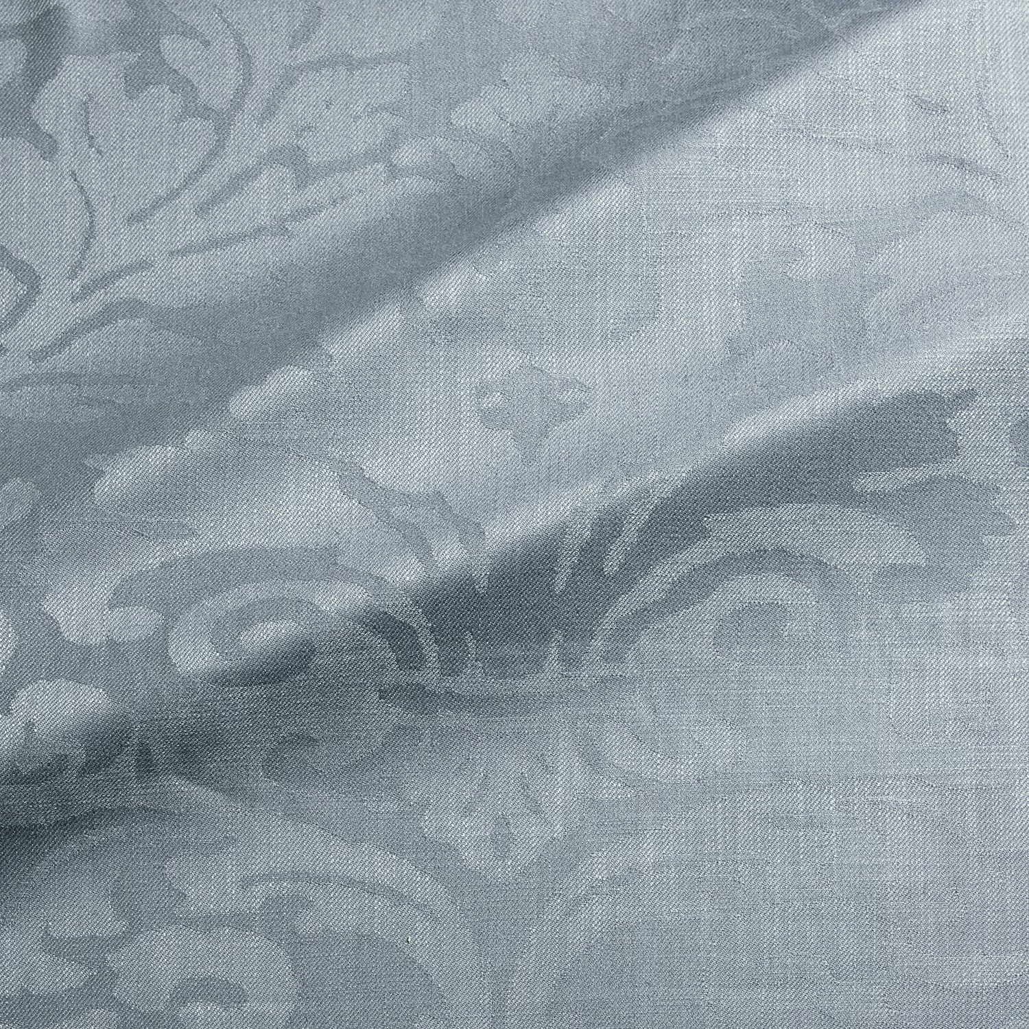Close-up of cool mineral blue-grey woven damask with scrolling floral motifs