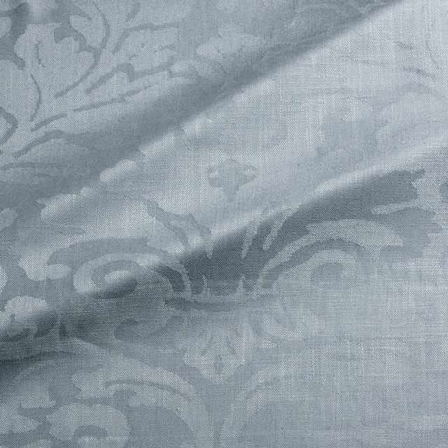 Close-up of cool mineral blue-grey woven damask with scrolling floral motifs