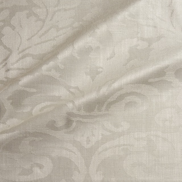 Pale almond damask with low-contrast scrolling motifs and a fine woven surface