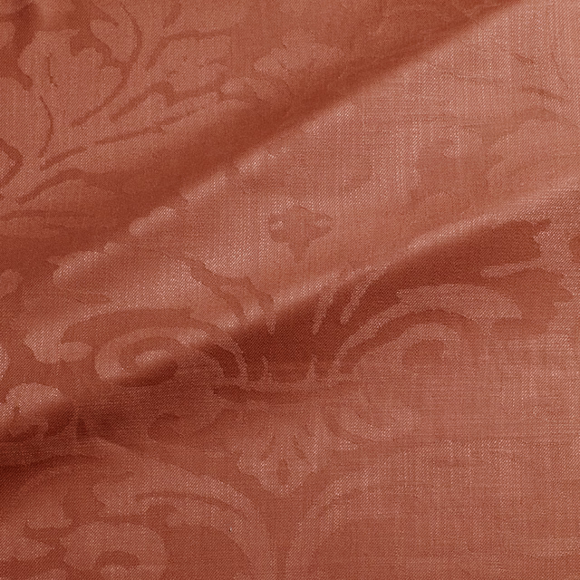 Muted terracotta damask fabric with burgundy tonal motifs and fine woven texture