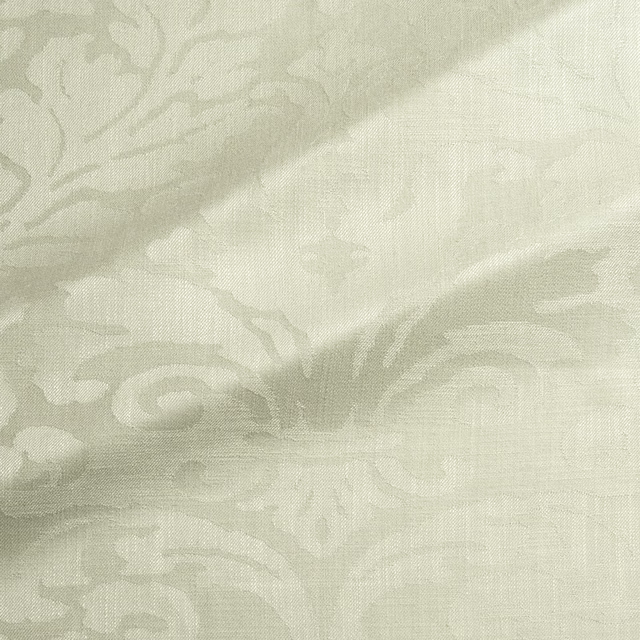 Pale pistachio-green woven damask with softly raised scrolling motifs and visible fine texture
