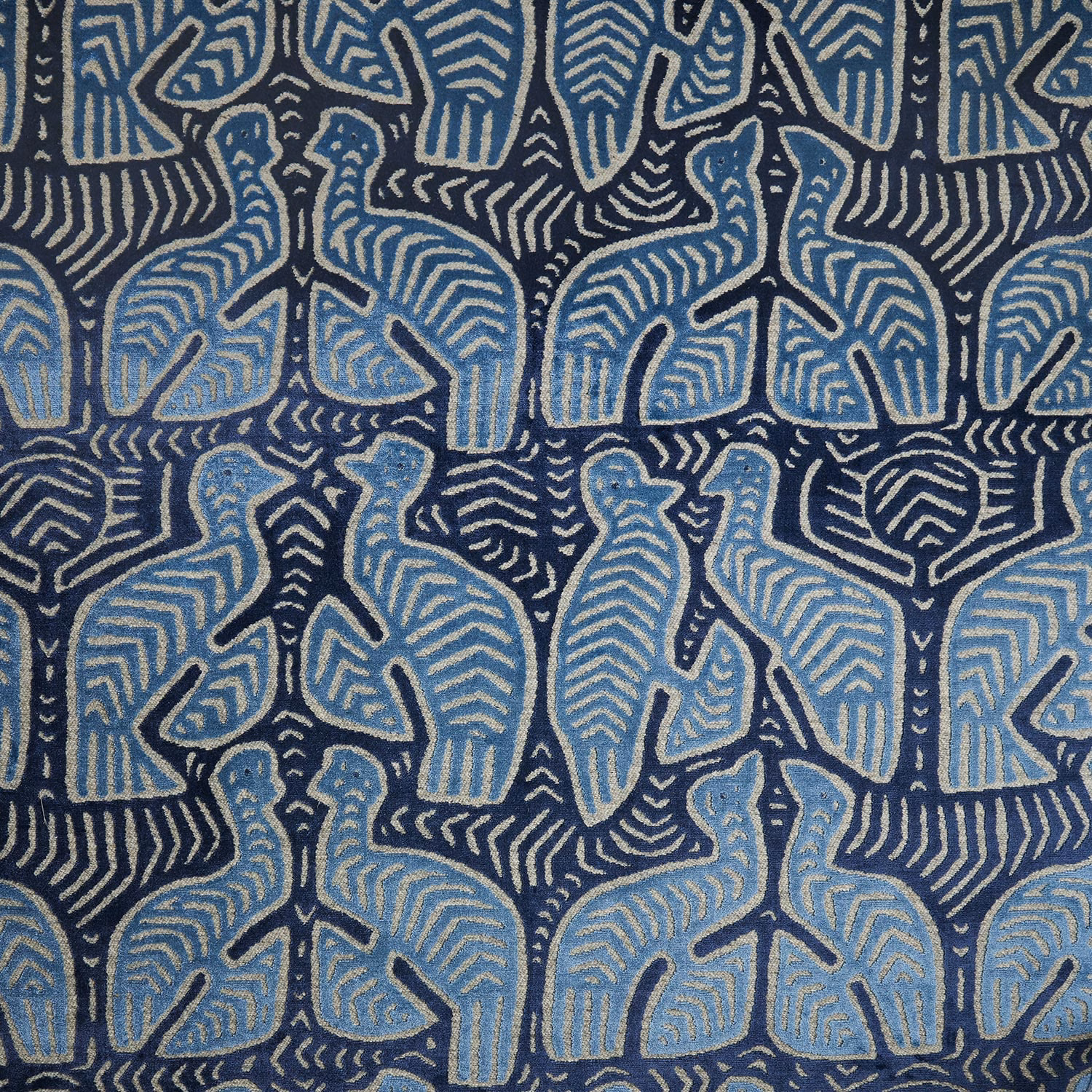 Dusty blue stylised elephants arranged on a textured deep navy patterned fabric