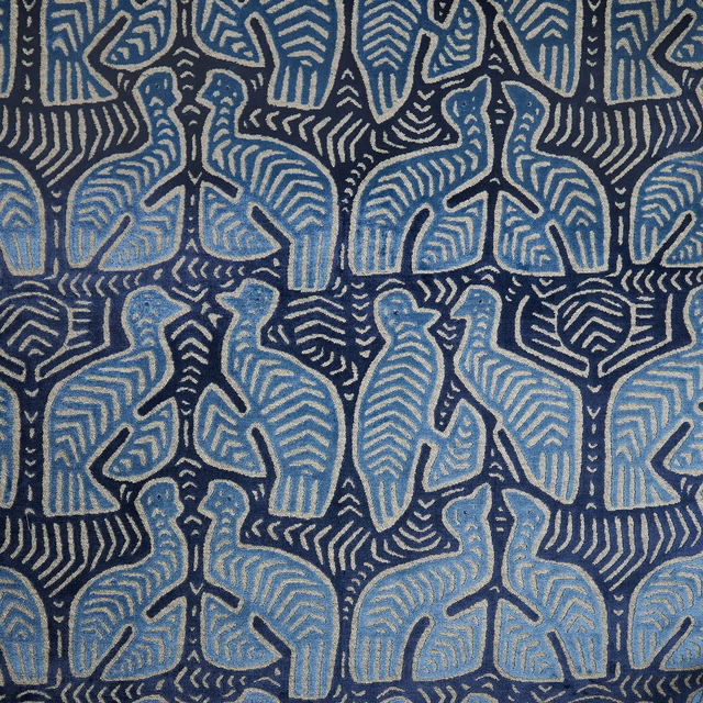 Dusty blue stylised elephants arranged on a textured deep navy patterned fabric