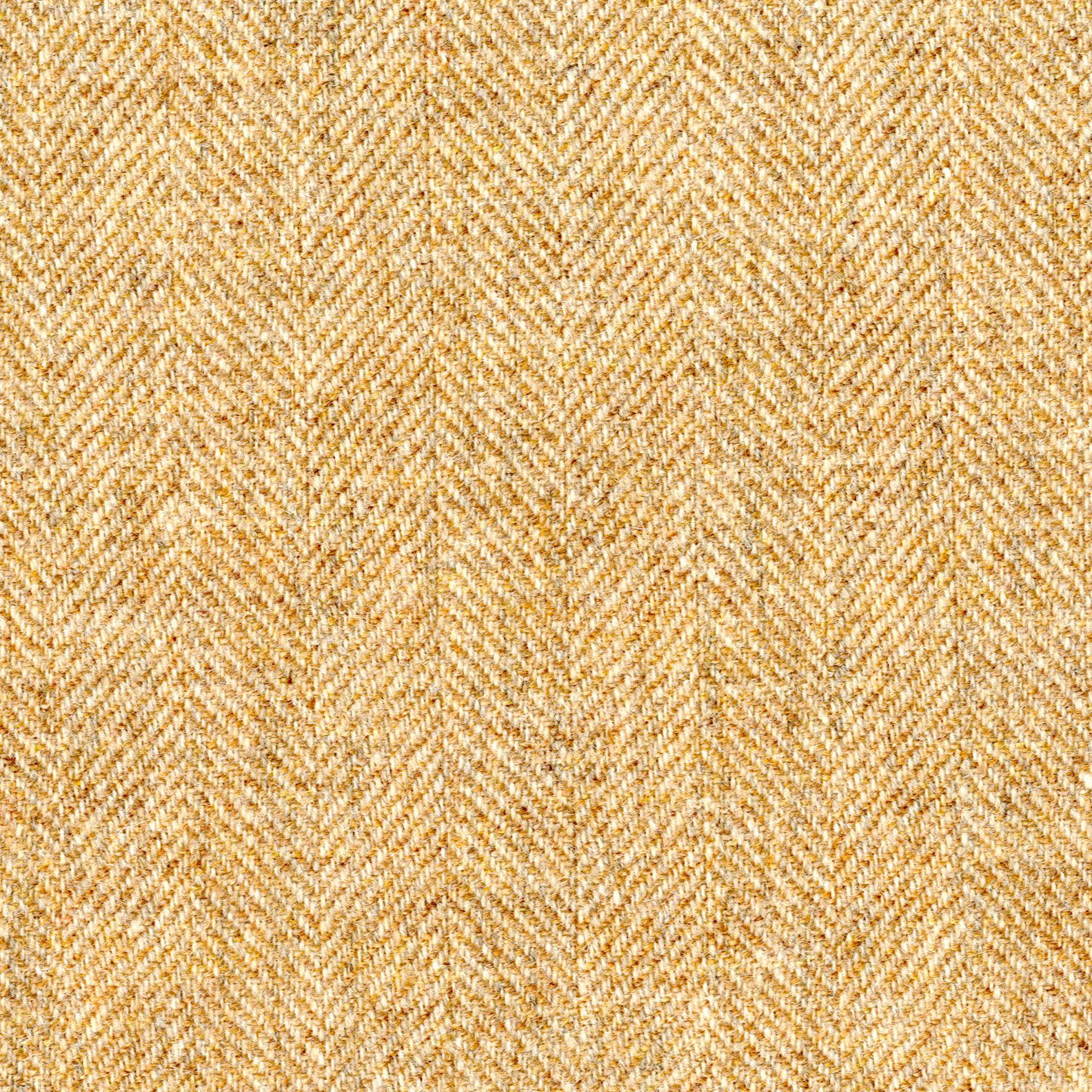 Warm golden-beige herringbone weave with fine flecked texture in close-up