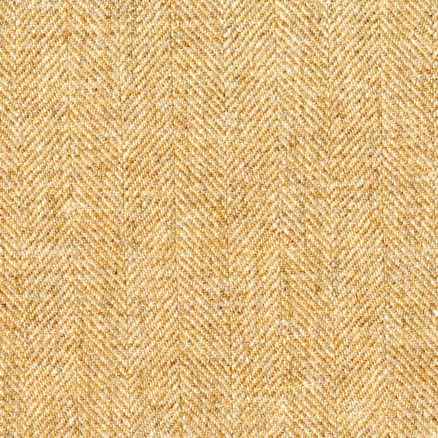 Warm golden-beige herringbone weave with fine flecked texture in close-up