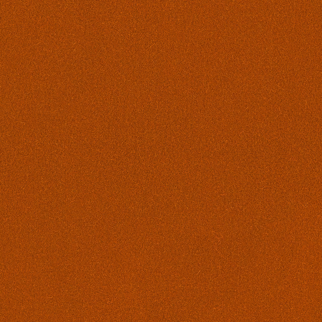 Close-up of warm burnt-orange Romney wool with a fine, subtly grainy weave