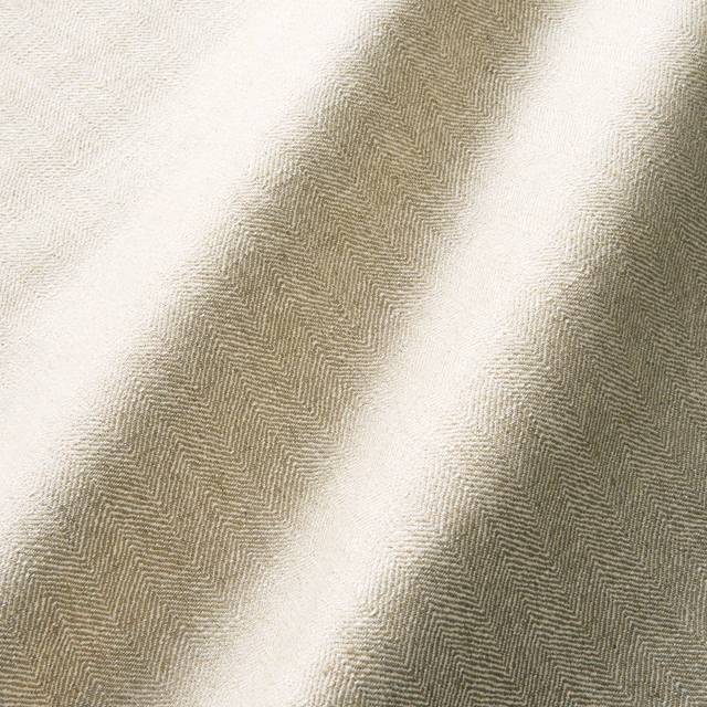 Warm biscuit-beige herringbone fabric draped in softly shadowed folds