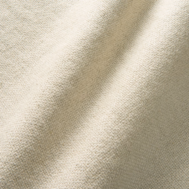 Warm ivory pumice fabric showing a fine nubby weave across softly folded cloth
