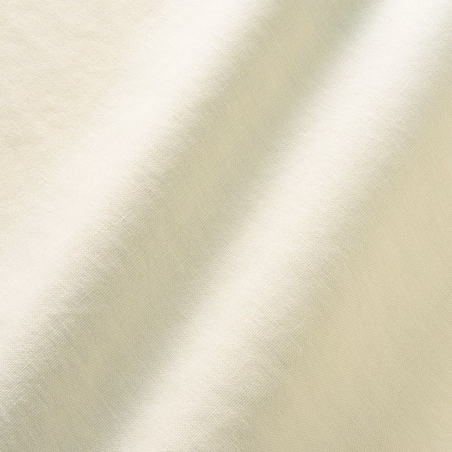 Close-up of ivory fabric with pale sage-grey cloudy bands and fine woven texture