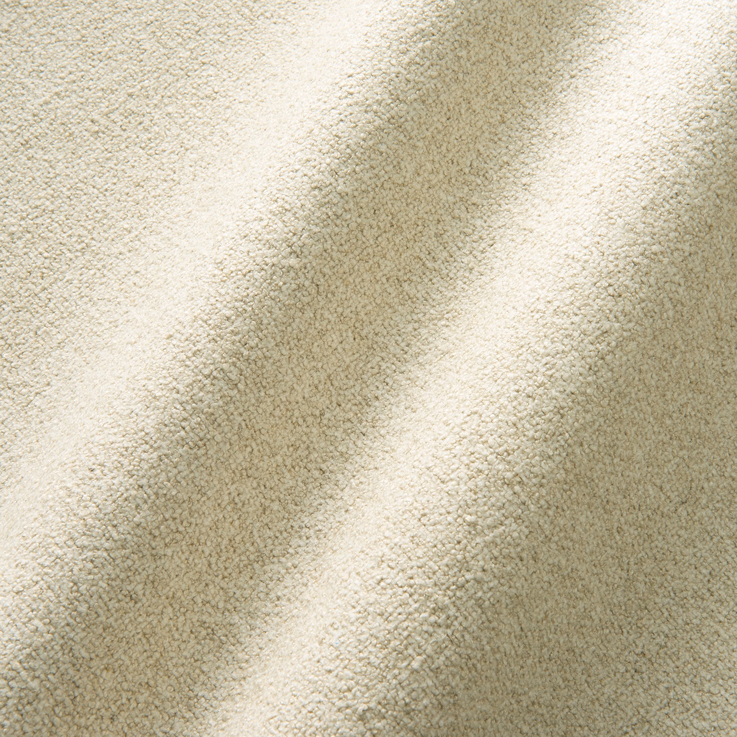 Close-up of warm almond cream woven fabric with softly nubby texture and shaded folds