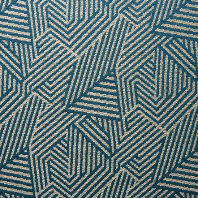 Blue-teal woven fabric with cream interlocking chevrons and angular stripes