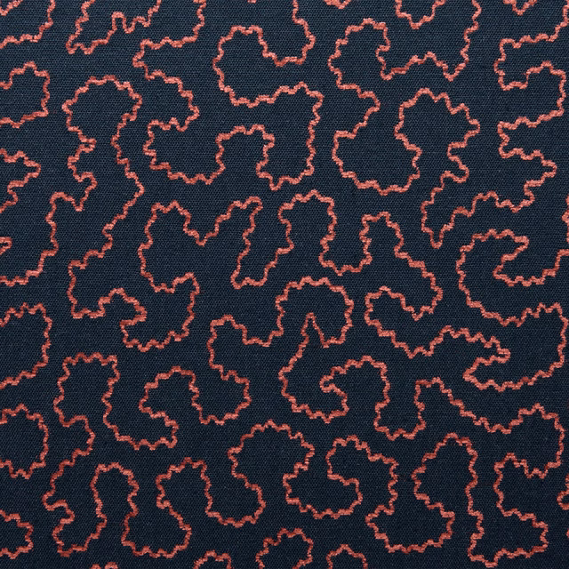 Deep navy woven fabric with small irregular coral-pink squiggle outlines