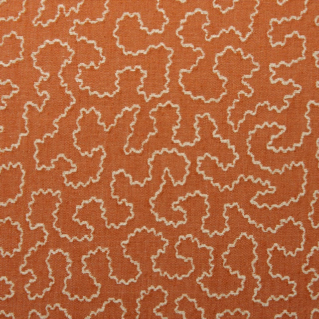 Terracotta woven fabric with cream irregular outlined motifs and visible textured weave