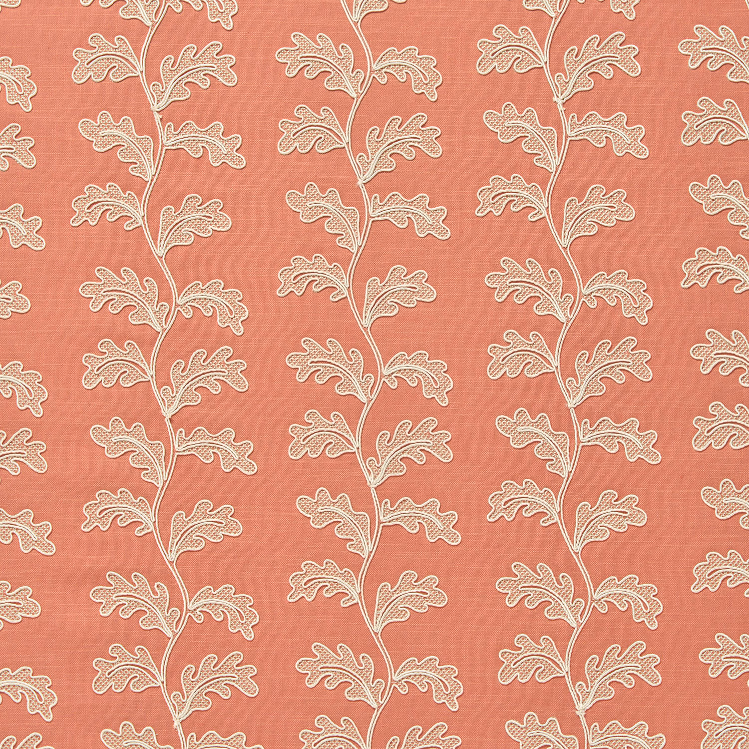 Coral pink woven fabric with ivory trailing leaf motif and subtle slub texture