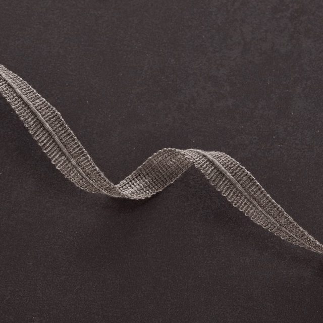 Dark gunmetal textile with a raised, looping grey wave across its matte surface
