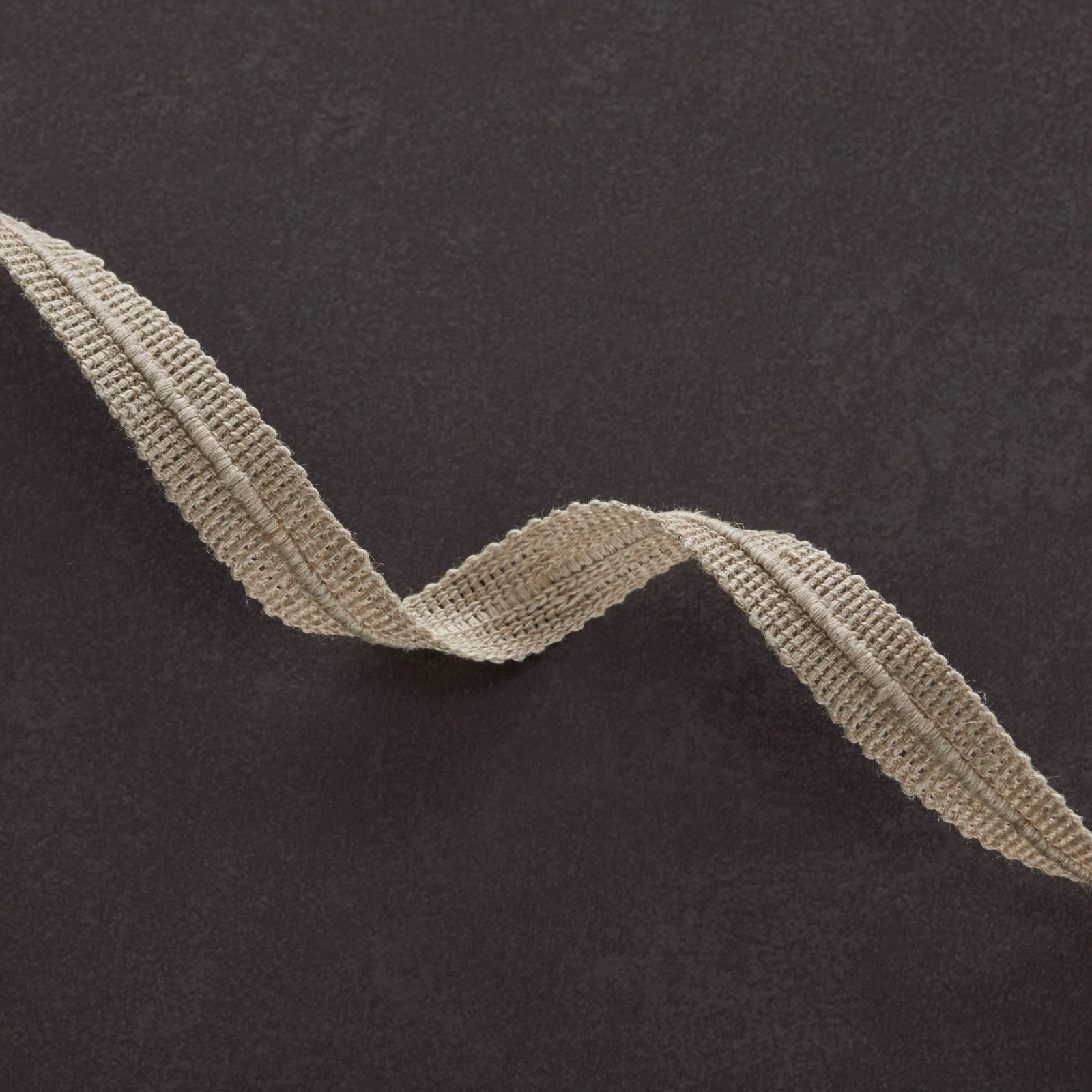 Charcoal fabric with a raised natural-beige wavy woven line across its surface