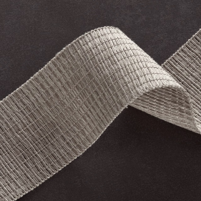 Cool cement-grey ribbed weave folded into a sculptural loop on dark ground