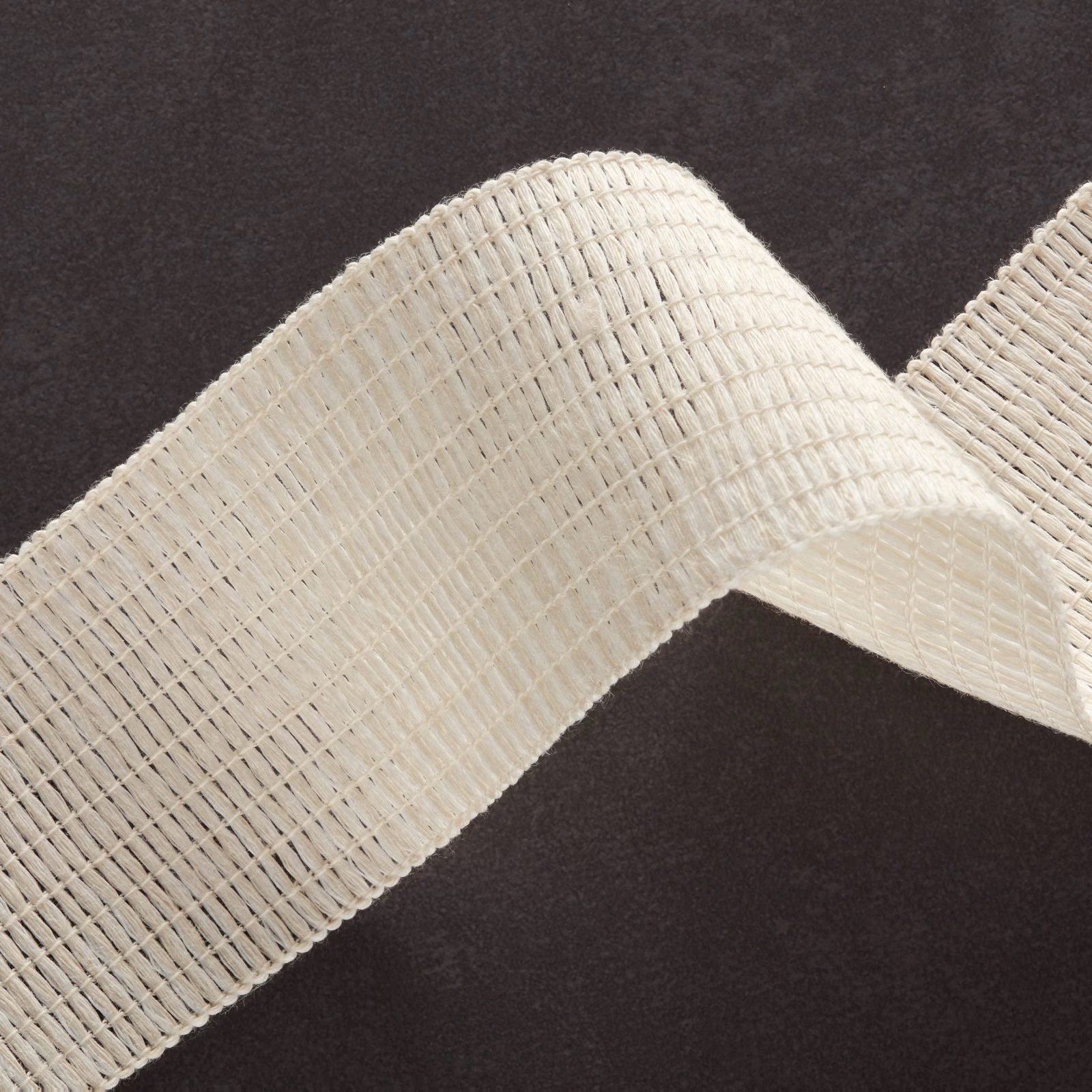 Warm ivory open-weave textile folded into a softly ridged, dimensional swatch