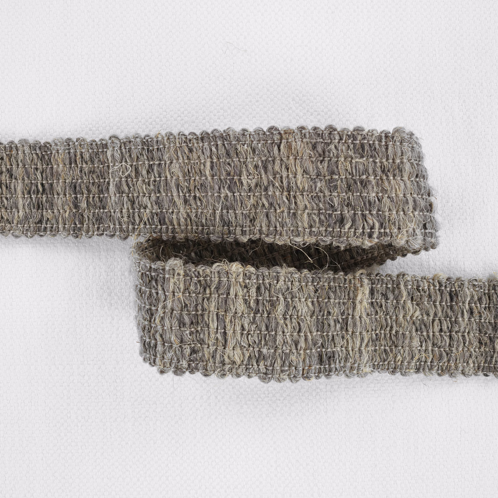 Close-up of taupe-grey Boulder fabric with dense irregular loops and darker threads