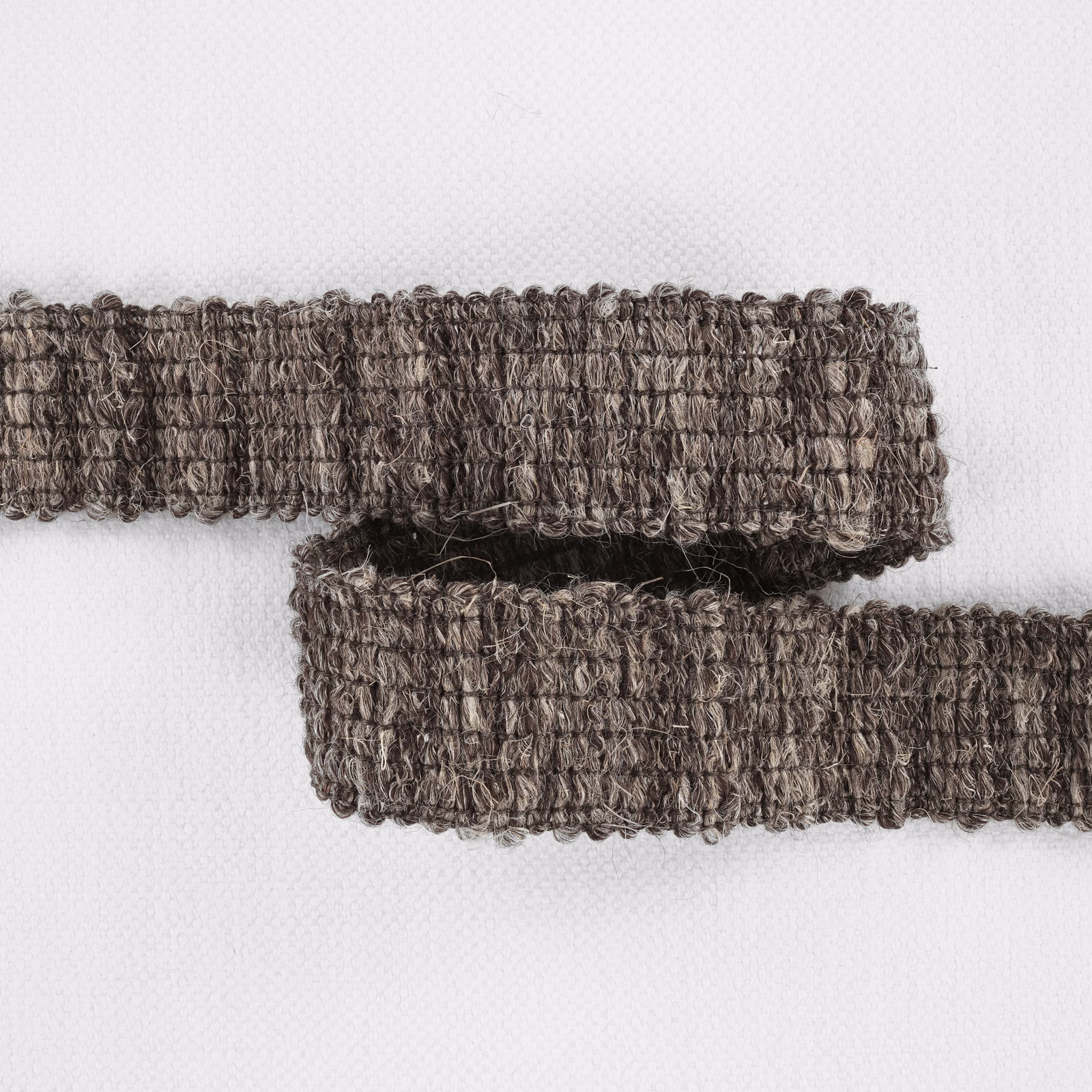 Two folded strips show Bordure Chestnut’s mottled chestnut-brown looped texture
