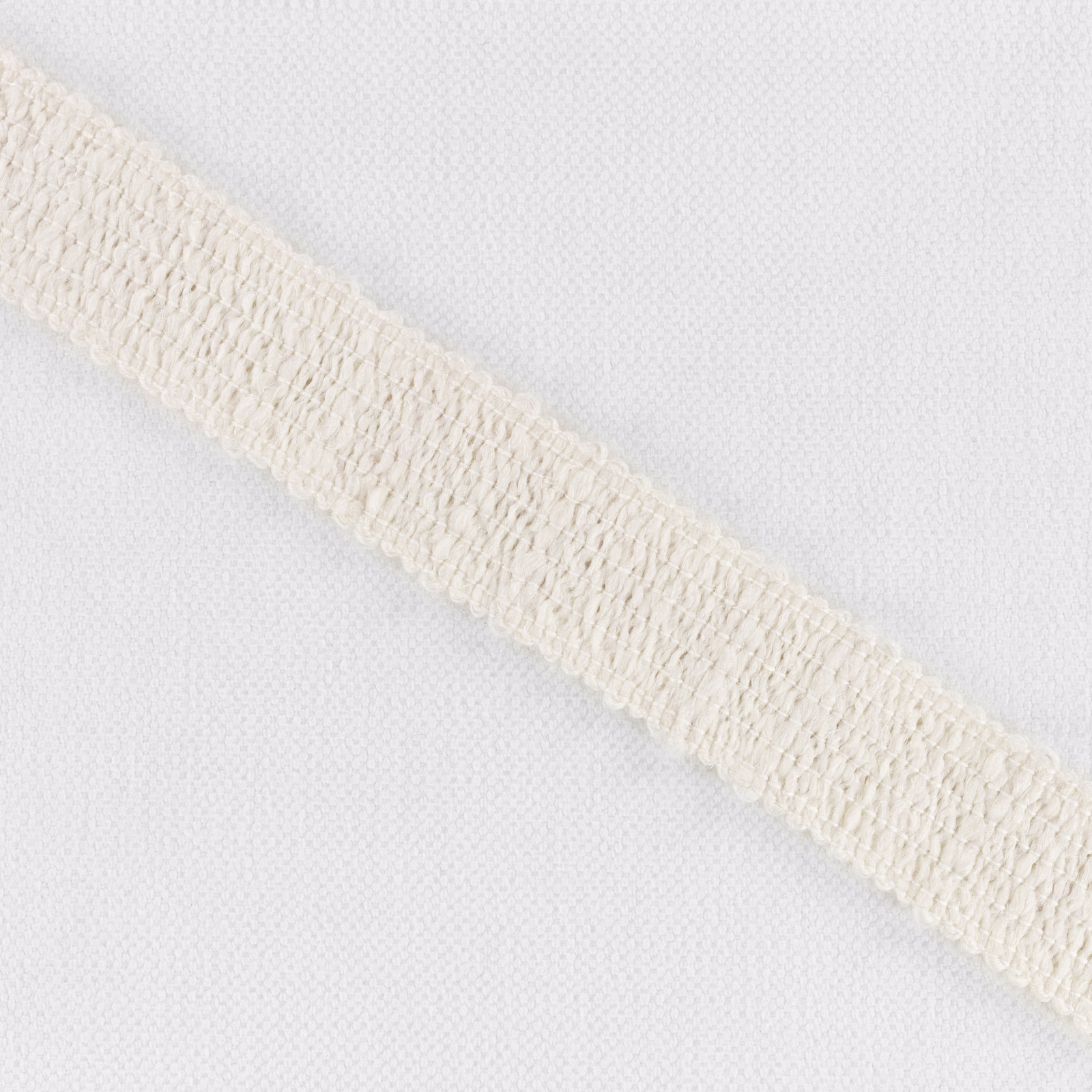 Pale ivory ground with a raised cream looped border crossing diagonally