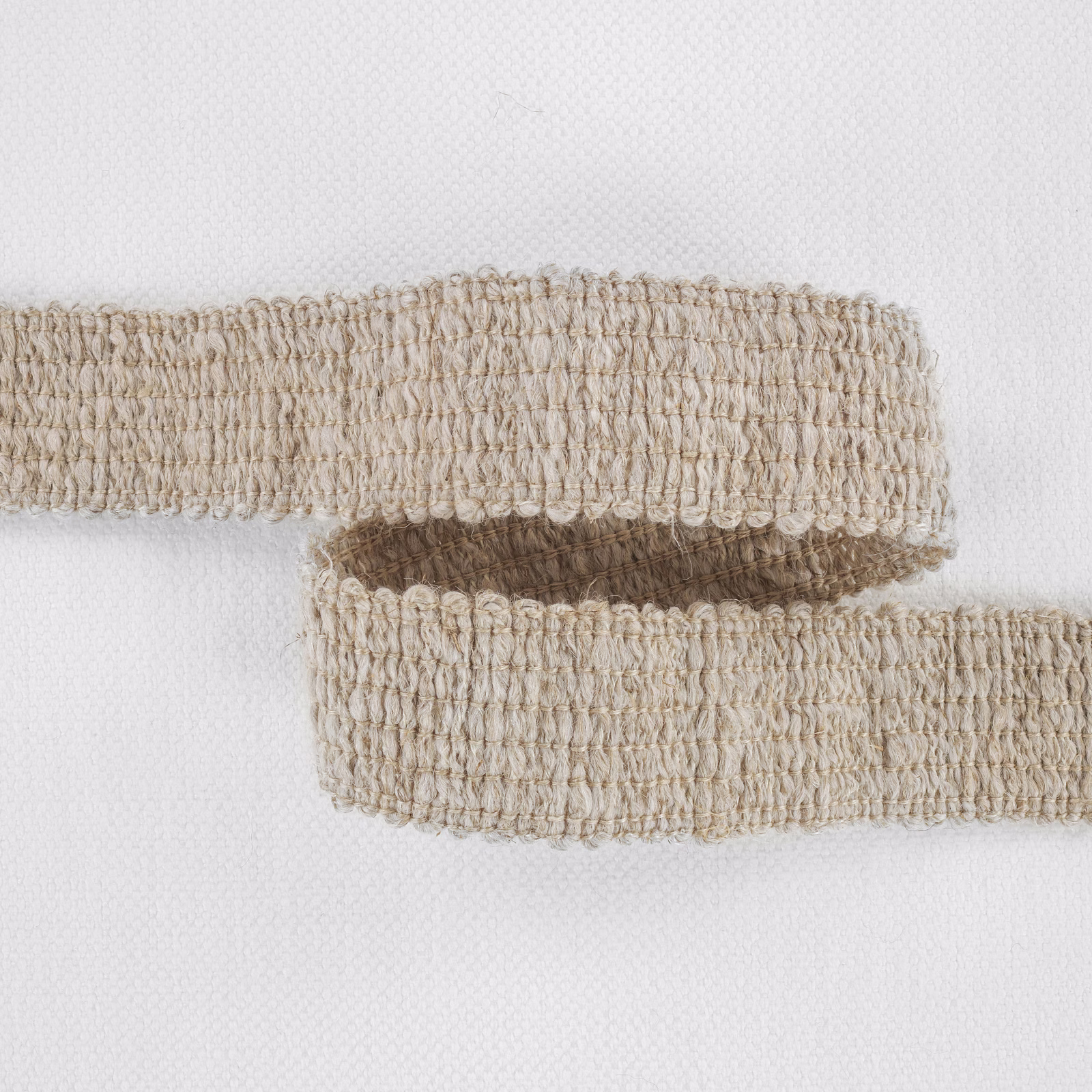 Warm natural beige fabric with dense raised loops and a softly mottled woven texture