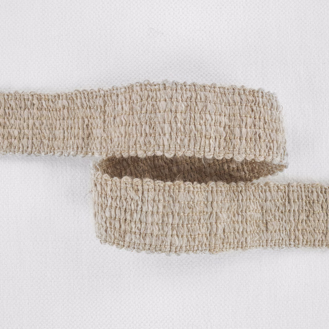 Warm natural beige fabric with dense raised loops and a softly mottled woven texture