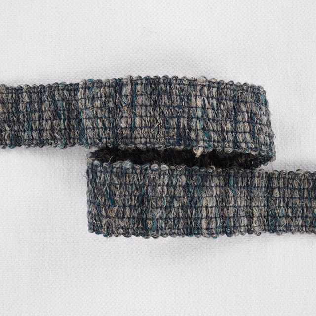 Overlapping muted teal, charcoal and taupe looped woven fabric bands on white