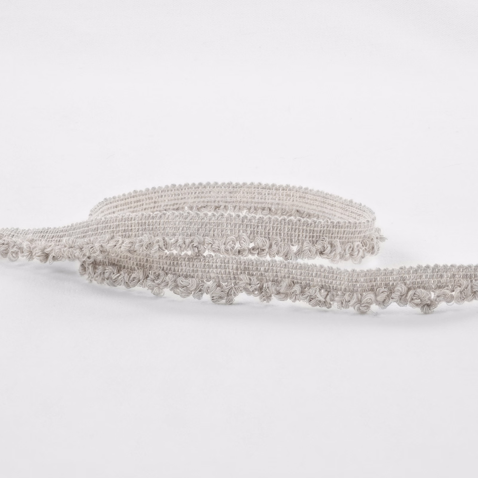 Pale greige boucle textile with raised loops and softly mottled silver-grey texture