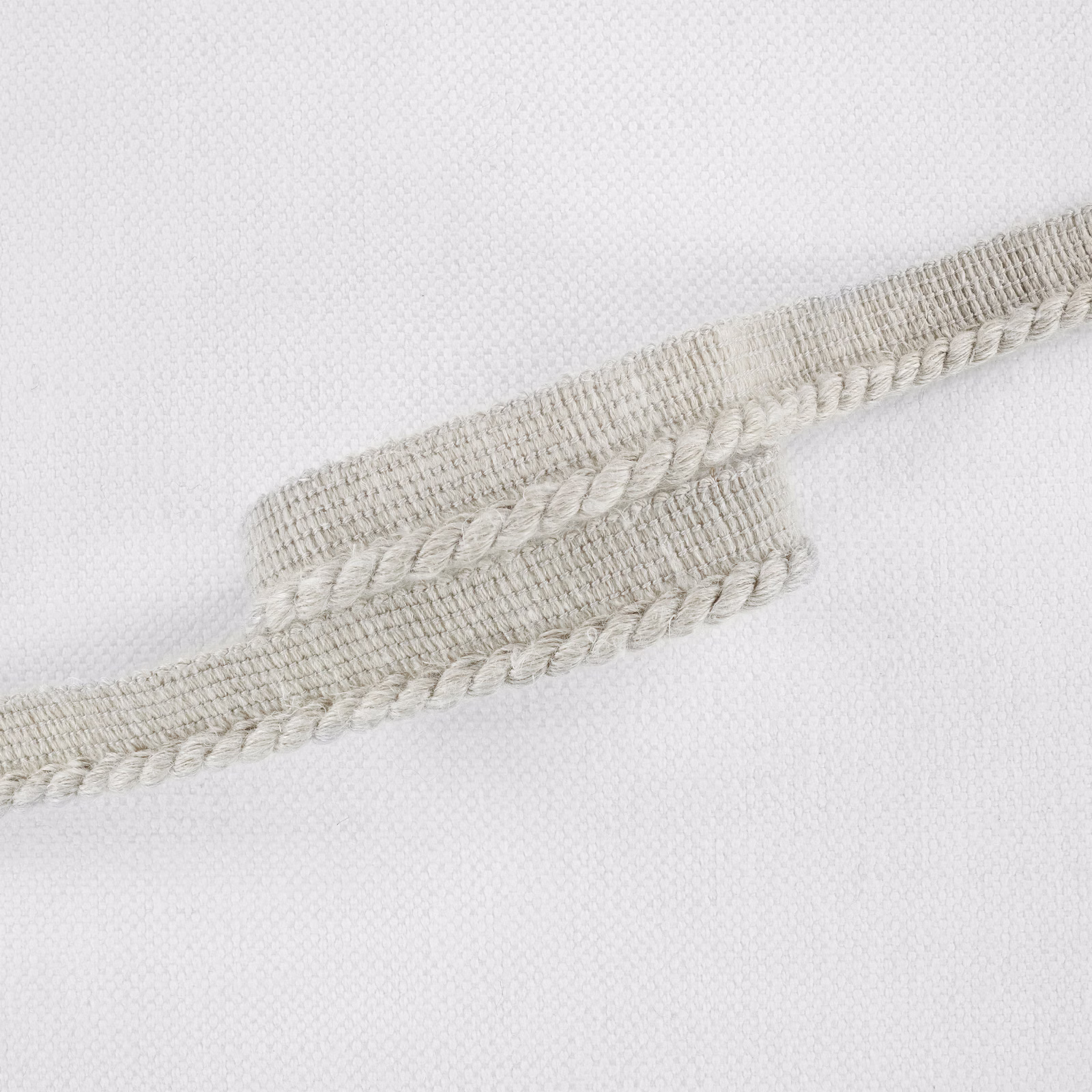 Pale greige woven textile with raised braided stripe on a fine ground