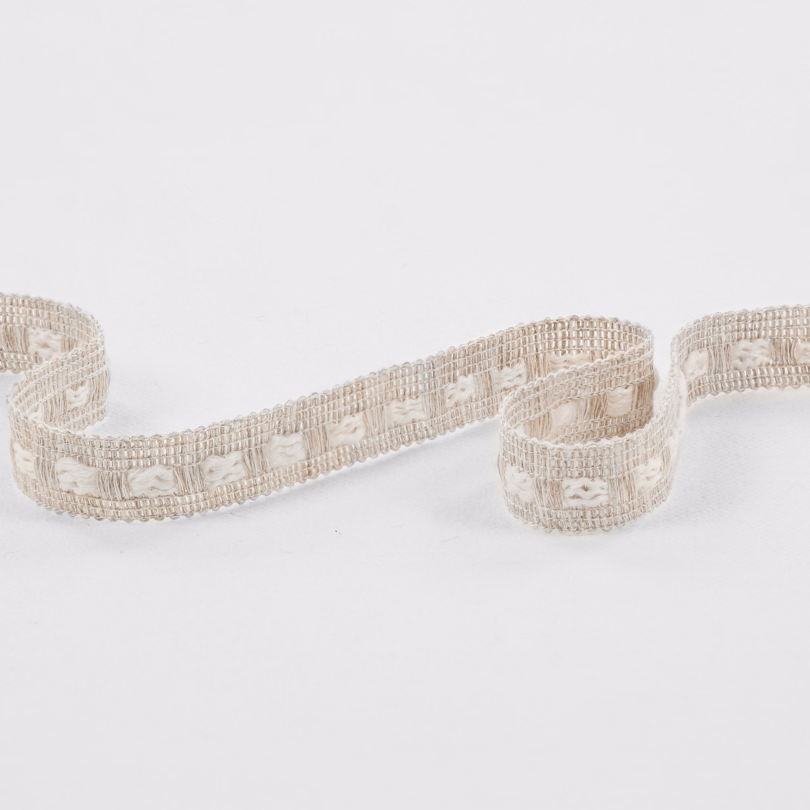 Ecru woven trim with raised loop motifs and ribbed edging