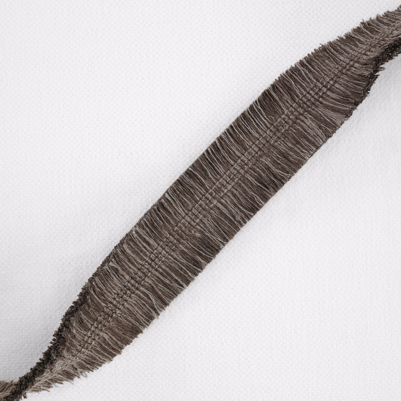 Chestnut-brown fringed diagonal stripe over a pale, finely textured ground