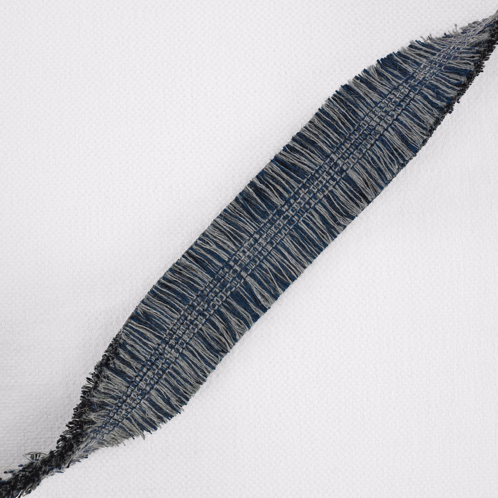Deep indigo woven swatch with pale crosshatched threads and softly fringed edges