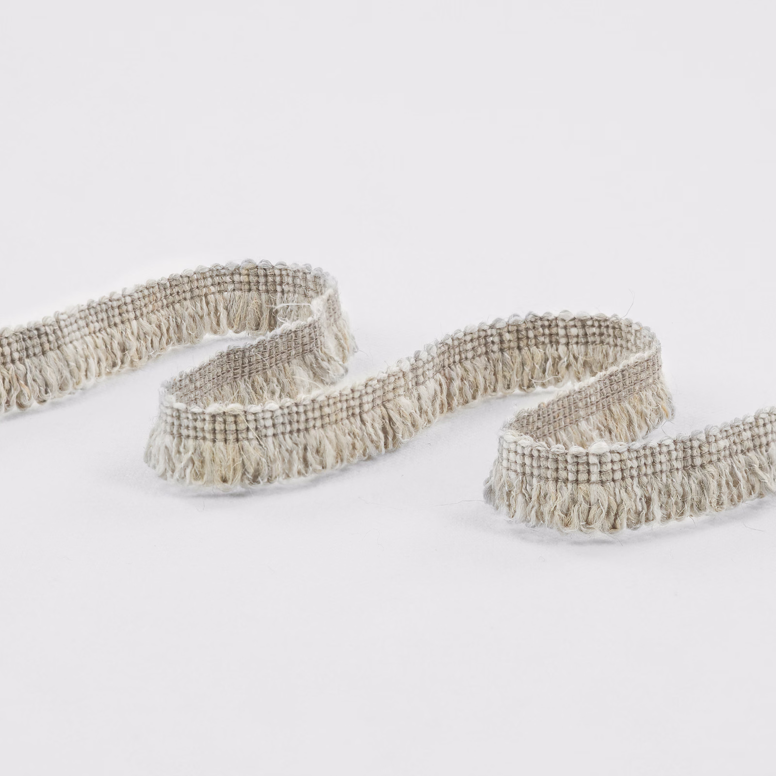 Curled cement-grey woven trim with oatmeal threads and a softly fringed edge