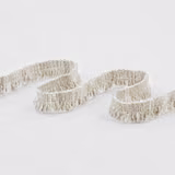 Warm ivory looped fringe fabric with dense raised woven texture in soft curves
