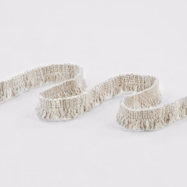 Warm ivory looped fringe fabric with dense raised woven texture in soft curves