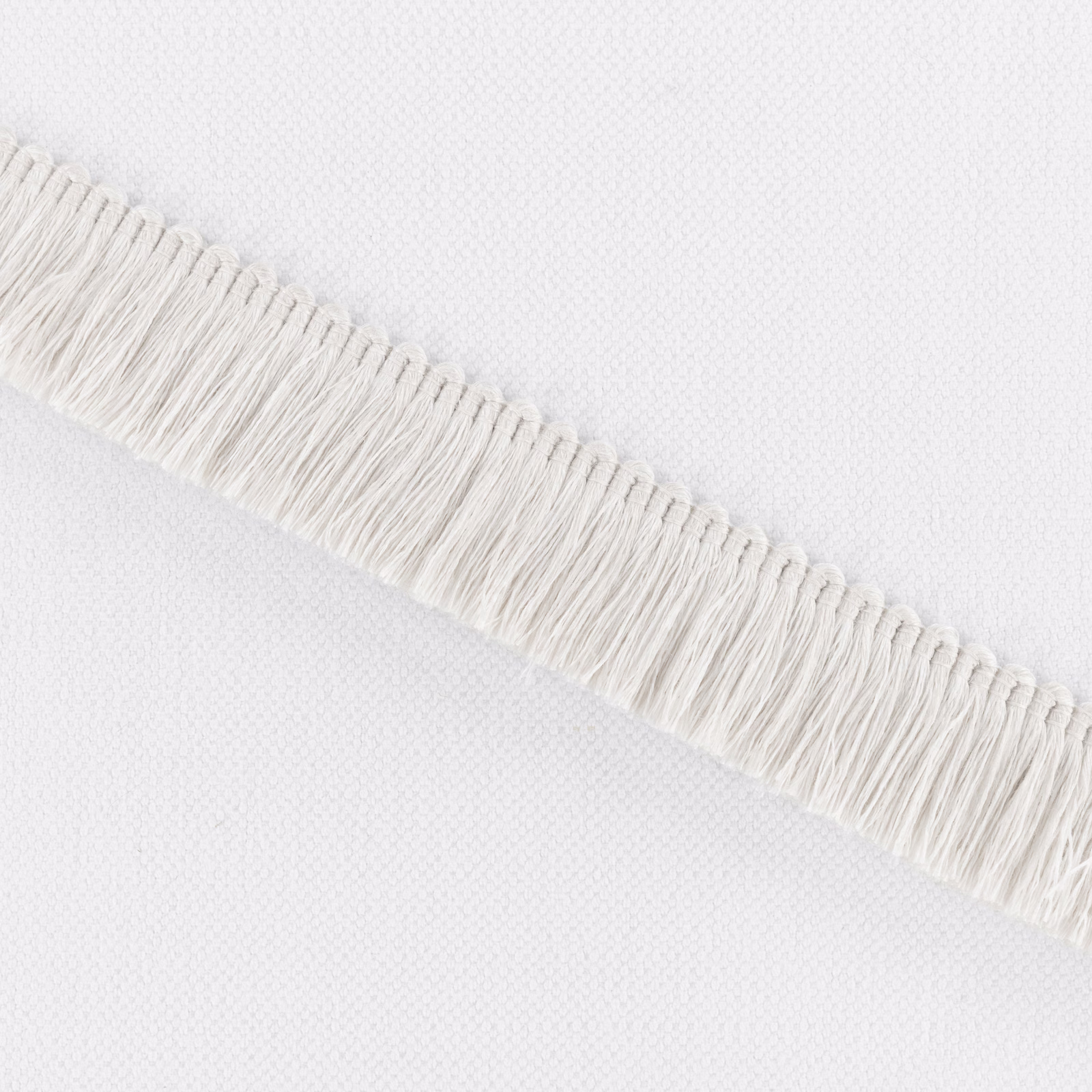 Soft ivory woven fabric with a diagonal band of long raised fringe
