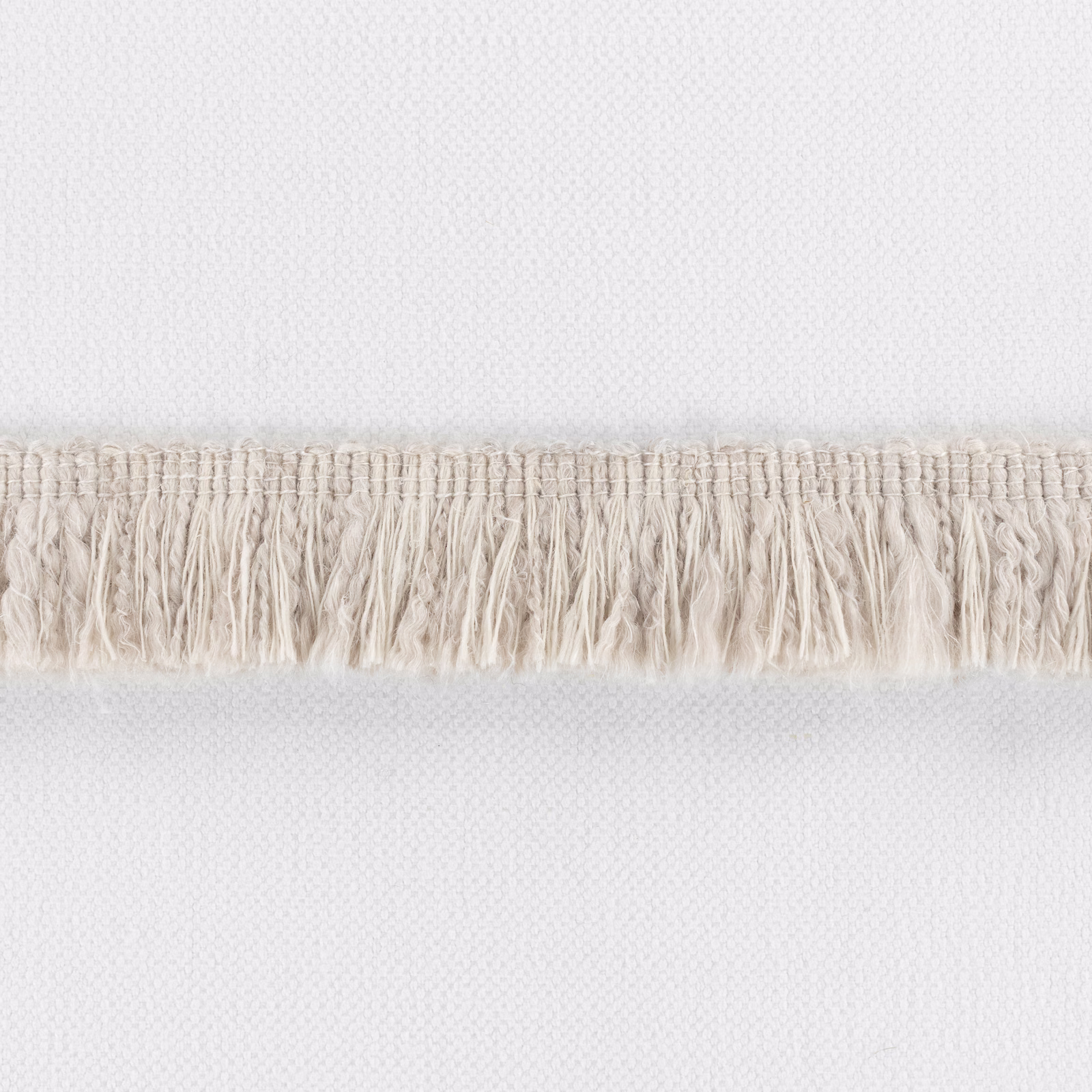 Pale plaster woven textile with fine texture and a horizontal cream fringe