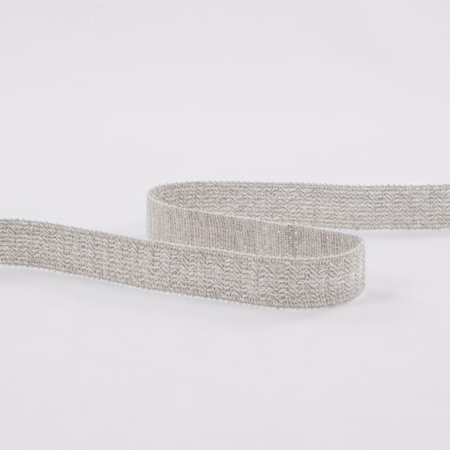 Pale ecru woven band with raised chevron texture, curled into soft loops