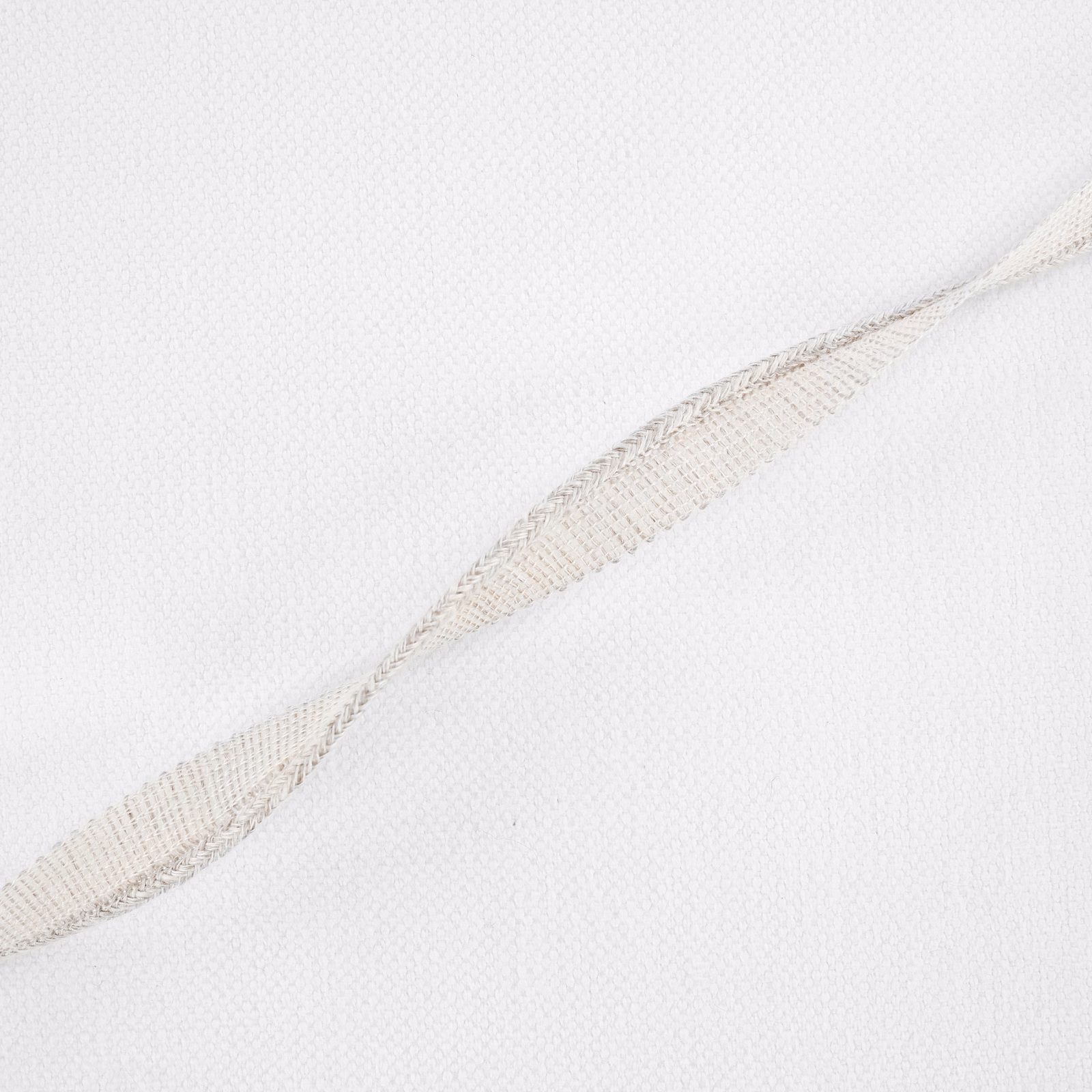 Pale ecru fine weave with a subtle beige feather-like motif running diagonally