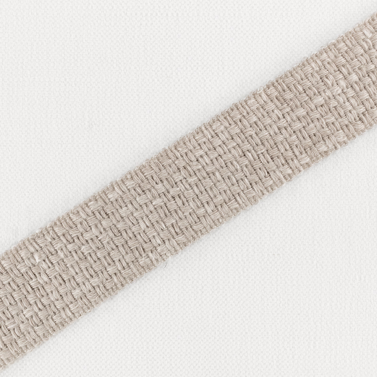 Ivory textile with a warm plaster-beige diagonal band in tactile basket weave