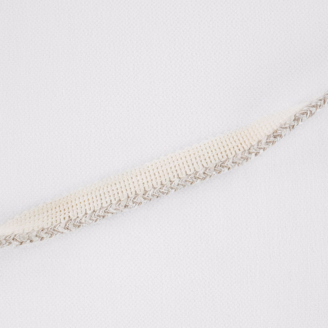 Pale ecru woven fabric with a raised braided band crossing diagonally